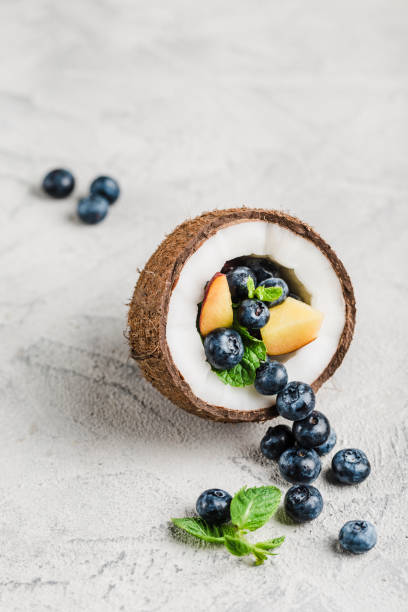 Fresh blueberries and peaches with mint bowl of coconut