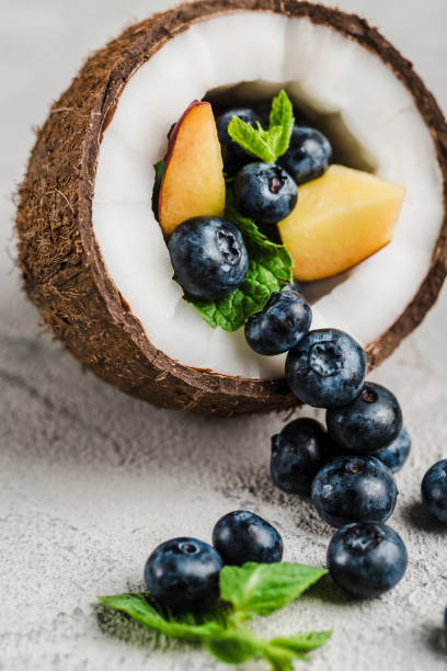 Fresh blueberries and peaches with mint bowl of coconut