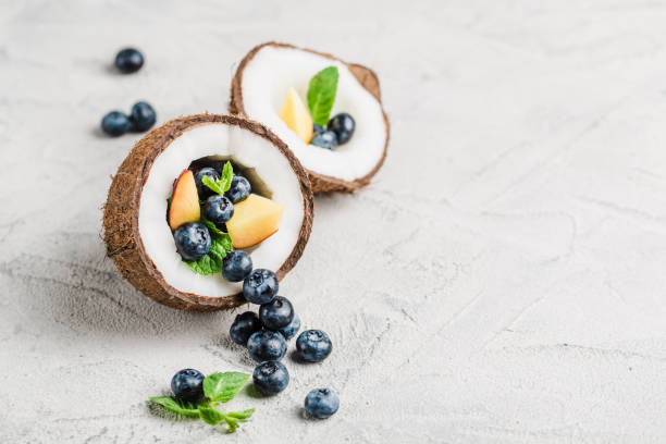 Fresh blueberries and peaches with mint bowl of coconut