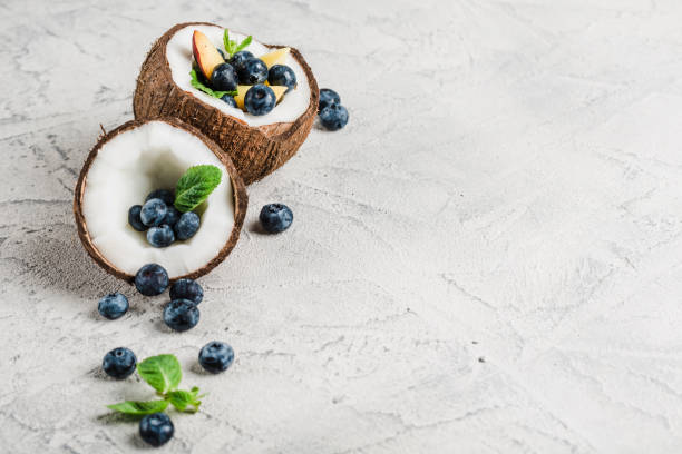 Fresh blueberries and peaches with mint bowl of coconut