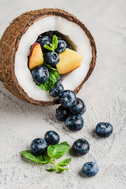Fresh blueberries and peaches with mint bowl of coconut