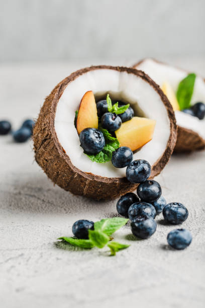 Fresh blueberries and peaches with mint bowl of coconut