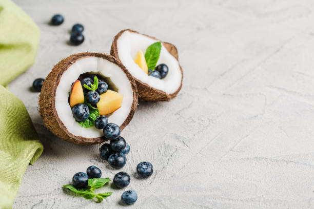 Fresh blueberries and peaches with mint bowl of coconut