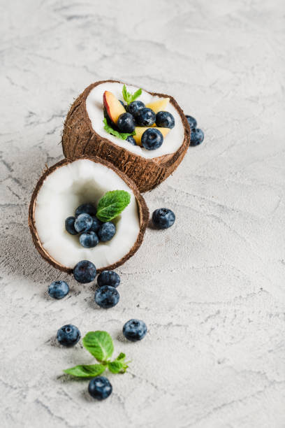 Fresh blueberries and peaches with mint bowl of coconut