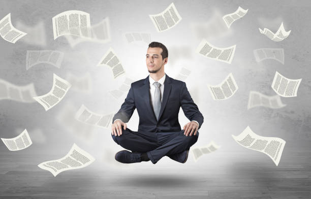 istock Businessman meditating with flying paper concept 1163582868