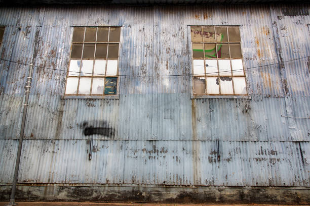 An old abandoned warehouse with rusted metal siding and broken windows as an example of urban blight located in the metropolitan Houston, Texas area.