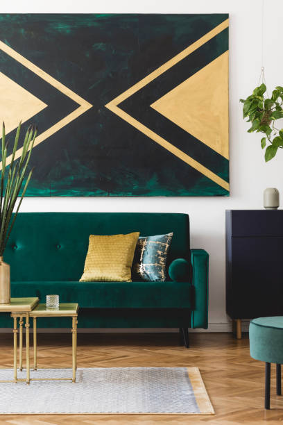 istock Luxury composition of home interior design with modern velvet sofa, pouf, shelf, pillows, coffee table, plants, elegant accessories and geometric paintings on the wall. Stylish home decor. Template. 1163592631