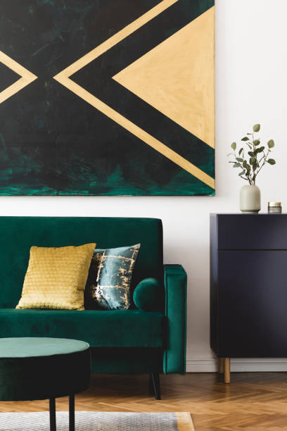 istock Stylish composition of home interior design with modern velvet sofa, pouf, shelf, pillows, flowers in vase, elegant accessories and geometric paintings on the wall. Nice home decor. Template. 1163592634