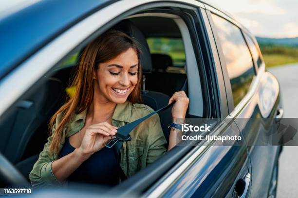 Photo Of A Business Woman Sitting In A Car Putting On Her Seat Belt Stock Photo - Download Image Now