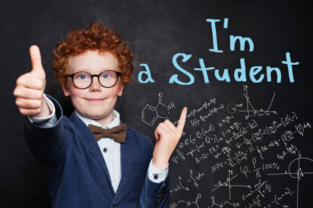 istock Happy curious child boy on blackboard background with science and maths formulas 1163598169