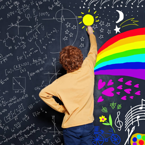 istock Young boy drawing science formulas and arts scetch on blackboard background 1163598195