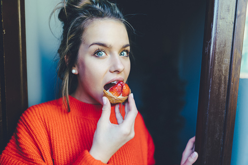 Hungry woman eating secretly sweet dessert