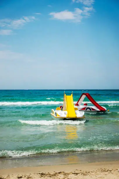 Two pedal-boats with water slides on the beach in Halkidiki, Greece.
