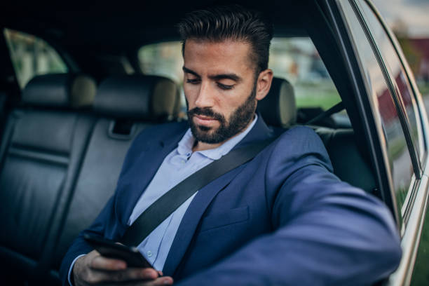 istock Businessman driving in a car text messaging 1163606035