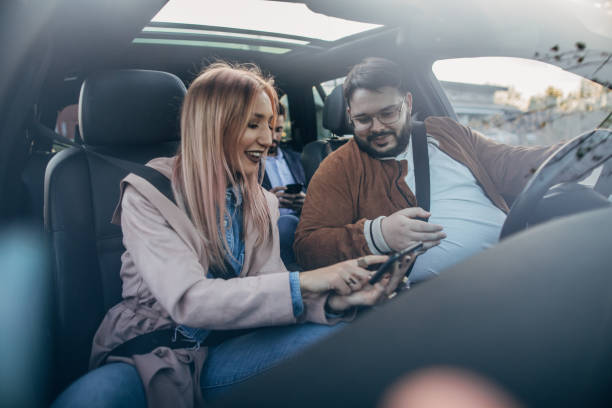 друзья, использующие навигацию на смартфоне - mobile phone seat belt text messaging smiling стоковые фото и изображения