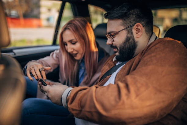 istock Friends using smart phone in a car 1163607306