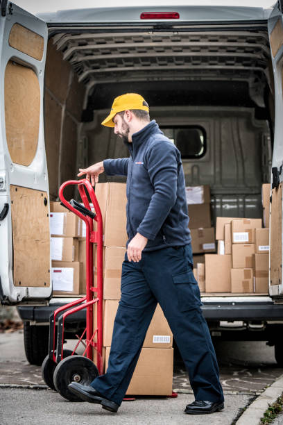 istock Delivery man with boxes on a push cart 1163610356