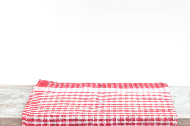 istock Empty wooden desk table and red checked tablecloth over mint wallpaper background 1163611938