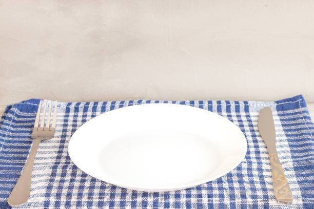 istock Empty plate on tablecloth or napkin on wooden table over cement background 1163611941