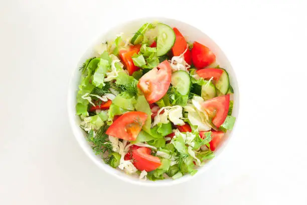 Fresh mixed vegetables salad in a bowl. Raw salad in white bowl on white background