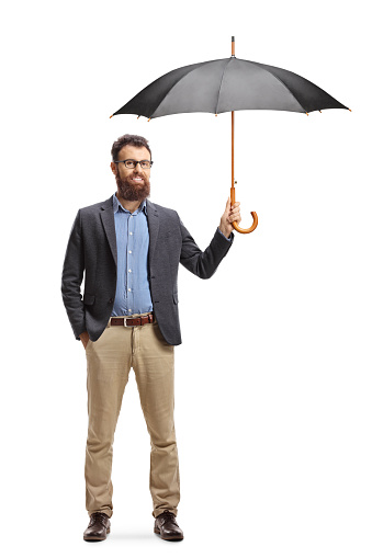 Full length portrait of a bearded young man standing and holding an open umbrella isolated on white background