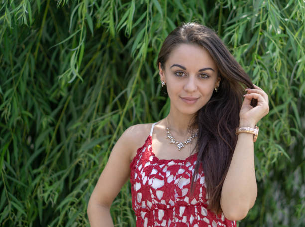 portrait of beautiful young woman in red dress in the park