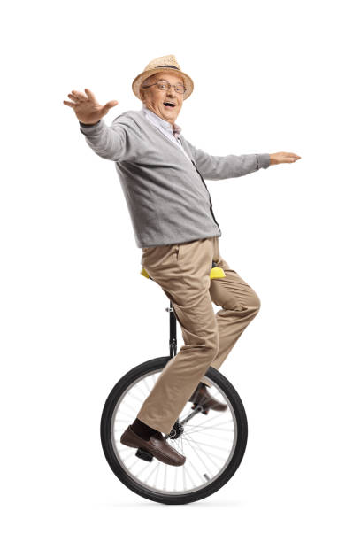 возбужденный пожилой человек верхом на одноколесном велосипеде - unicycle стоковые фото и изображения
