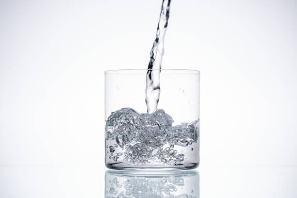 istock water pouring in glass on white background with backlit and copy space 1163615459