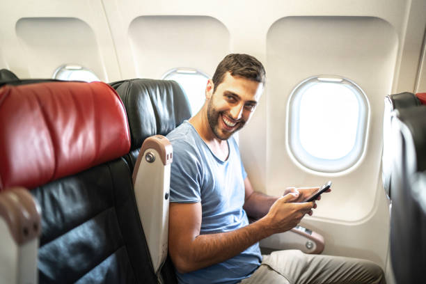 istock Portrait of a man in an airplane using cellphone 1163615610