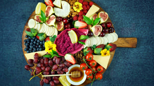 Cheese and fruit charcuterie dessert grazing platter on wooden board. Cheese and fruit charcuterie dessert grazing platter on wooden board overhead. grazing stock pictures, royalty-free photos & images