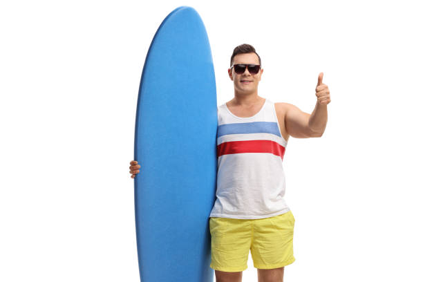 istock Young guy holding a surfboard and making a thumb up gesture 1163616880
