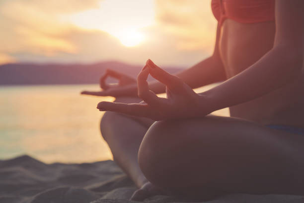 istock Young woman practicing yoga on the sandy beach. 1163617104