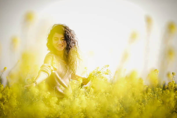 Woman collecting fragrant yellow flowers