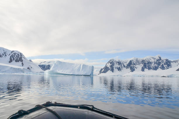 istock Zodiac boat facing an iceberg shaped by water 1163621278