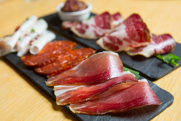 istock different kinds of cut ham on a wooden board 1163621549