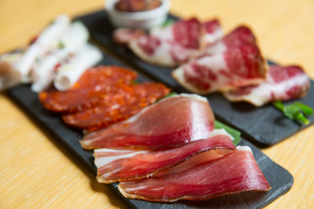 istock different kinds of cut ham on a wooden board 1163622511