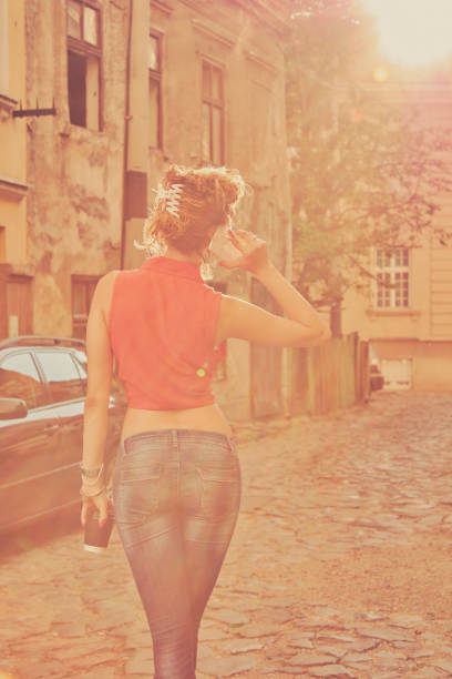 istock Beautiful woman using cellphone and drinking coffee on the street. 1163622654