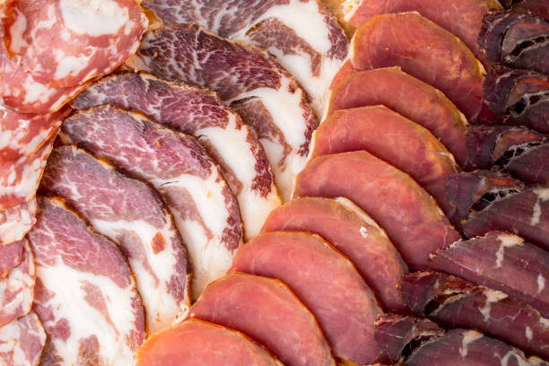 istock different kinds of cut ham on a wooden board 1163623454