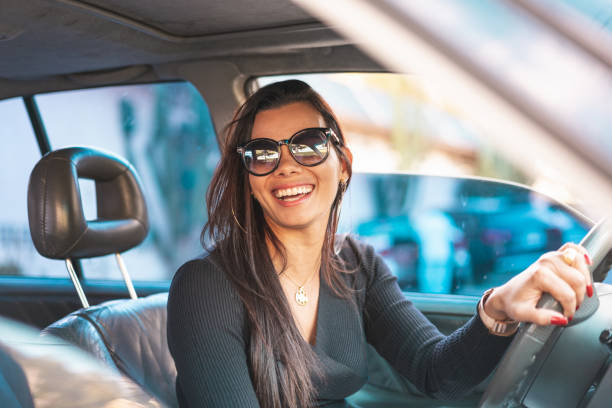 istock Happy brunette woman driving a car 1163628002