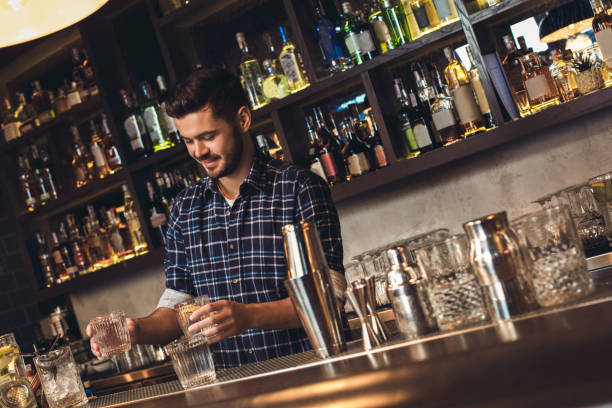 istock Young bartender standing at bar counter serving cocktails happy 1163630934