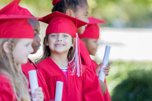 istock Cute kindergarten graduates line up outside before their graduation ceremony at elementary school 1163631181