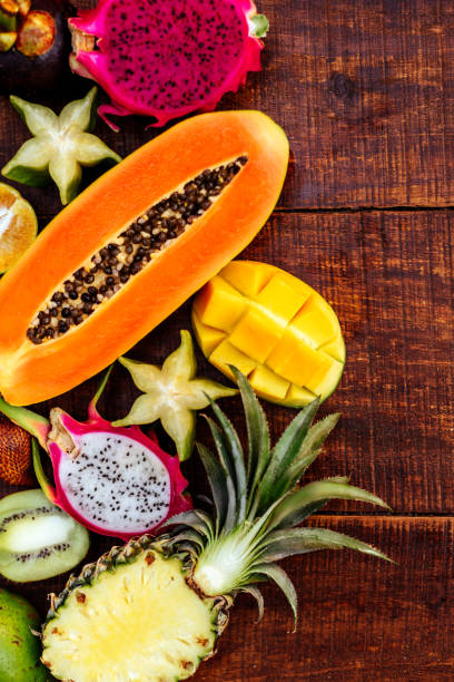 istock Tropical fruit on dark wooden background 1163632796
