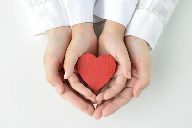 istock Heart object held by child and mom's hands 1163632885