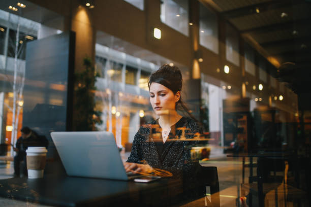 istock Young woman finishing work outdoors by the cafe on the go 1163632985