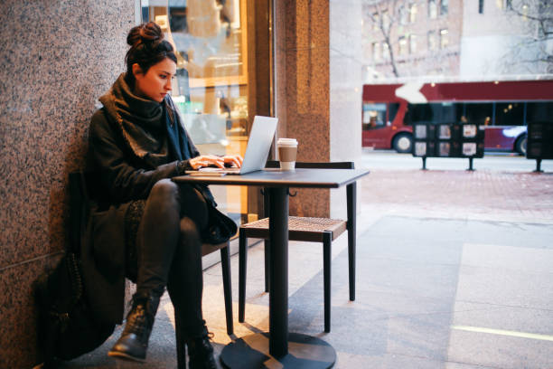 istock Young woman finishing work outdoors by the cafe on the go 1163633071