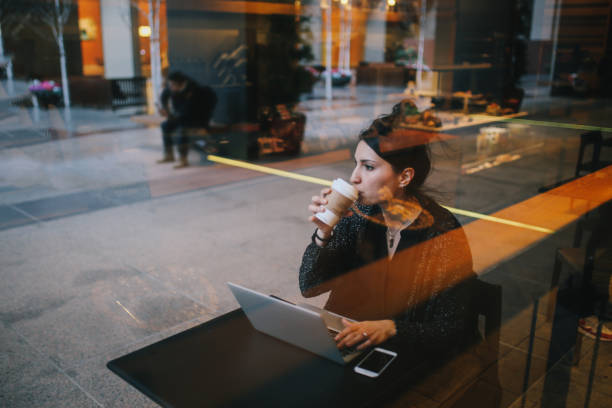 istock Young woman finishing work outdoors by the cafe on the go 1163634465