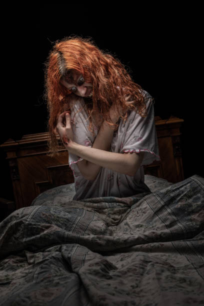 istock Scary woman possessed by devil in the bed. Exorcism of priest. 1163638647