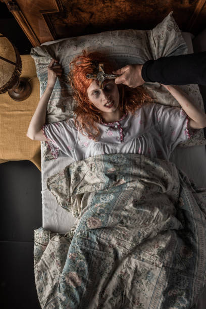 istock Scary woman possessed by devil in the bed. Exorcism of priest. 1163640337