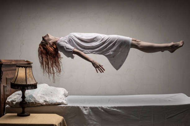 Woman levitating over bed / astral traveling, nightmare, excorcist halloween concept Woman levitating over bed / astral traveling, nightmare, excorcist halloween concept exorcism stock pictures, royalty-free photos & images