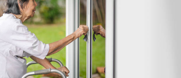 istock Elderly woman with key opening front door. 1163641849